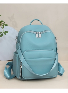 Detail of blue lychee grain leather backpack with silver zippers and side pockets