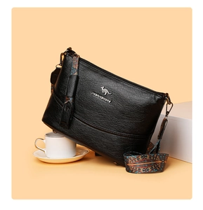 Detailansicht der schwarzen Beuteltasche aus Leder mit Logo und buntem Ethno-Gurt
