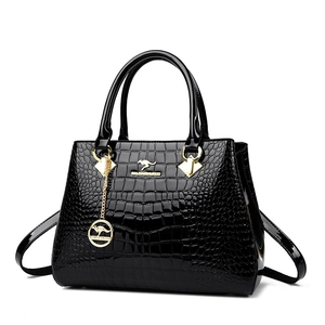 Glossy black crocodile pattern handbag for women with elegant golden hardware and charms
