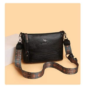 Detail der Eimer-Tasche aus Leder mit Litschi-Muster und buntem Ethno-Webschultergurt