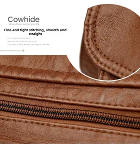 Detailed close-up of brown cowhide leather stitching and metallic zipper on baguette bag