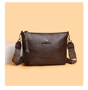 Details der braunen Leder-Beuteltasche mit Känguru-Logo und floralem breitem Gurt