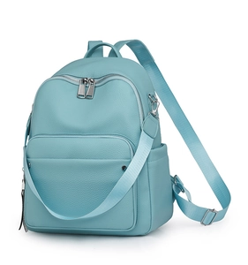 Detail of light blue pebble leather backpack showing front zipper and side pocket