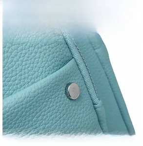 Macro shot of sky blue pebble leather texture with silver rivet and nylon zipper detail