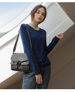 Close-up of a vintage dark grey multi-pocket crossbody bag with cool buckle detail