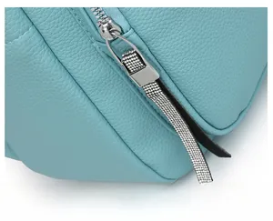 Close-up of light blue lychee leather texture and silver zipper with diamond details