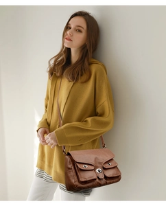 Brown vintage baguette bag with front pockets and silver twist lock shown on model