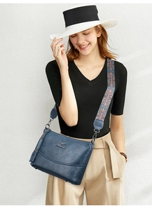 Detail der blauen Eimer-Tasche mit buntem Ethno-Schultergurt getragen von einem Model