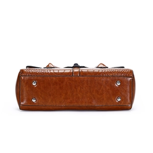 Vue du bas du sac à main en cuir verni marron avec gaufrage croco et pieds en métal