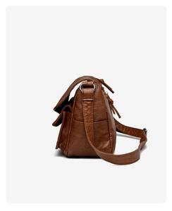 Detail shot of vintage brown leather bag featuring tassel zipper and side storage pocket