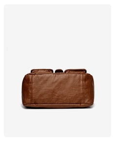 Macro detail of the brown leather bag base showing stable structure and dual stitching