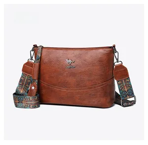 Detail der braunen Leder-Eimertasche mit gewebtem Riemen und Metall-Logo-Details