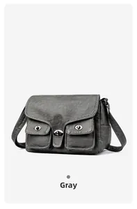 Front detail of a grey vintage baguette bag featuring dual metal twist locks and PU texture