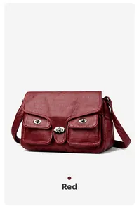 Detail of wine red crossbody bag featuring dual front pockets and metallic twist locks
