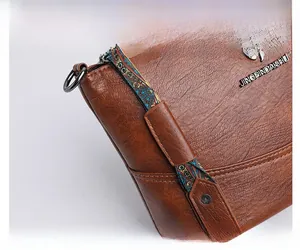 Nahaufnahme der braunen Kunstledertasche mit buntem gewebtem Riemen im Ethno-Stil