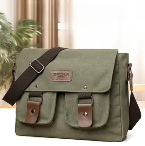 Detail of army green canvas messenger bag with brown leather straps and adjustable shoulder strap