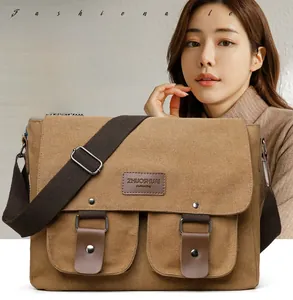 Detail of khaki canvas messenger bag featuring leather buckle straps and dual front pockets