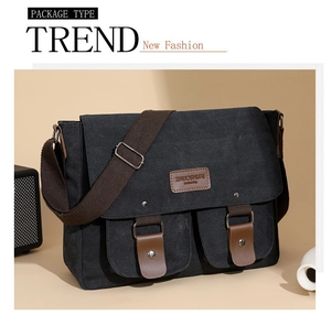 Close-up of black canvas messenger bag with brown leather logo and magnetic pockets