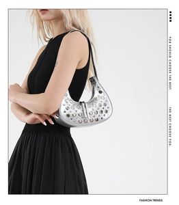Detailed view of silver crescent hobo bag featuring punk style metal rivets and thin strap