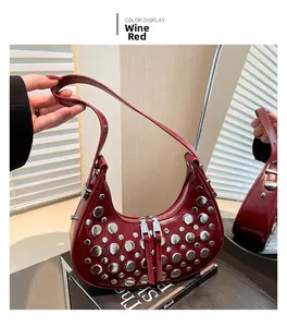 Macro shot of burgundy glossy leather shoulder bag with silver studs and mirror detail