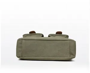Detailed bottom view of olive green canvas crossbody bag showing durable base construction