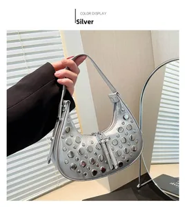 Close-up of metallic silver hobo bag with round rivet accents and long zipper pull detail