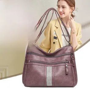 Detail of purple litchi grain leather shoulder bag with silver rhinestone decor and zippers