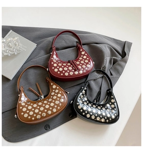 Detailed shot of half-moon handbags in three colors with silver metallic stud decor