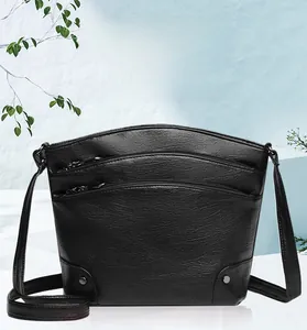 Detail of black lychee grain PU leather shoulder bag with multiple silver metal zippers