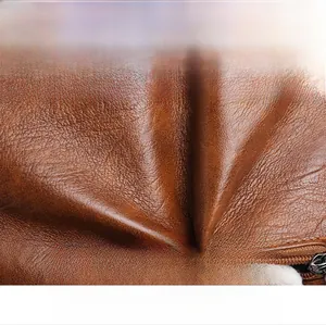 Macro shot of brown pebble grain leather bucket bag with zipper and soft texture