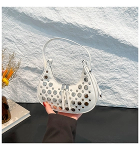 Detailed view of white hobo bag with silver rivets and dual zipper closure