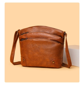 Detail view of brown vintage bucket bag featuring multi-layer zippers and metal rivets