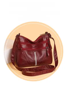 Detailed macro of burgundy faux leather texture and multiple zipper pockets on tote