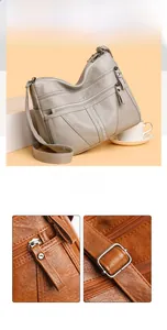 Detail view of multi-pocket soft leather shoulder bag with zippers and rhinestone accents
