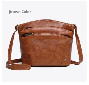 Detail view of brown vintage crossbody bucket bag with multi-layer zippers and metal buckles