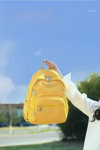 Sac à dos en nylon jaune imperméable et léger pour femme avec plusieurs poches zippées