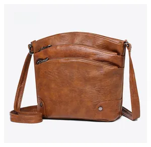 Detail view of caramel multi-layer crossbody bucket bag with retro texture and studs