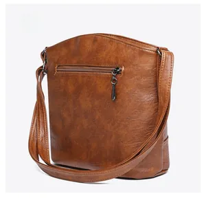 Detail view of the brown vintage bucket bag showing the back zipper pocket and leather texture