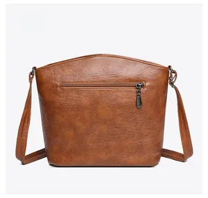 Back view of brown textured leather bucket bag featuring a horizontal zipper pocket
