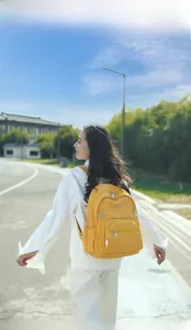 Détail d'un sac à dos en nylon jaune imperméable avec plusieurs poches zippées pratiques