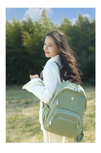 Détail du sac à dos en nylon vert clair imperméable avec fermetures éclair sur l'herbe