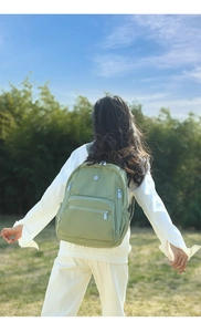 Sac à dos en nylon imperméable vert pois vue de dos dans un environnement extérieur naturel
