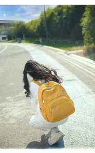 Détail d'un sac à dos en nylon imperméable jaune vif avec plusieurs poches zippées