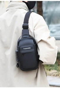 Detail view of anti-theft combination lock on black waterproof shoulder bag for men