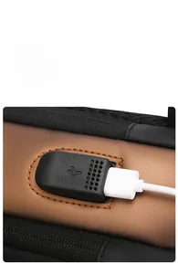Close-up of the built-in USB charging port with a cable on this anti-theft sling bag