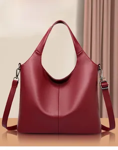 Detail of burgundy pebbled leather texture and silver hardware on women's tote bag