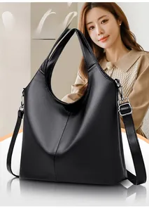 Detail shot of black pebbled leather texture and adjustable shoulder strap on a hobo bag