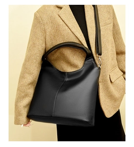 Close-up of black pebble leather tote bag with silver hardware and adjustable strap