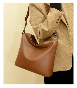 Caramel brown pebbled leather shoulder bag with integrated handle and adjustable strap