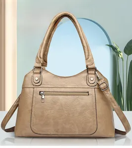 Detail view of khaki PU leather handbag with front zipper pocket and detachable strap